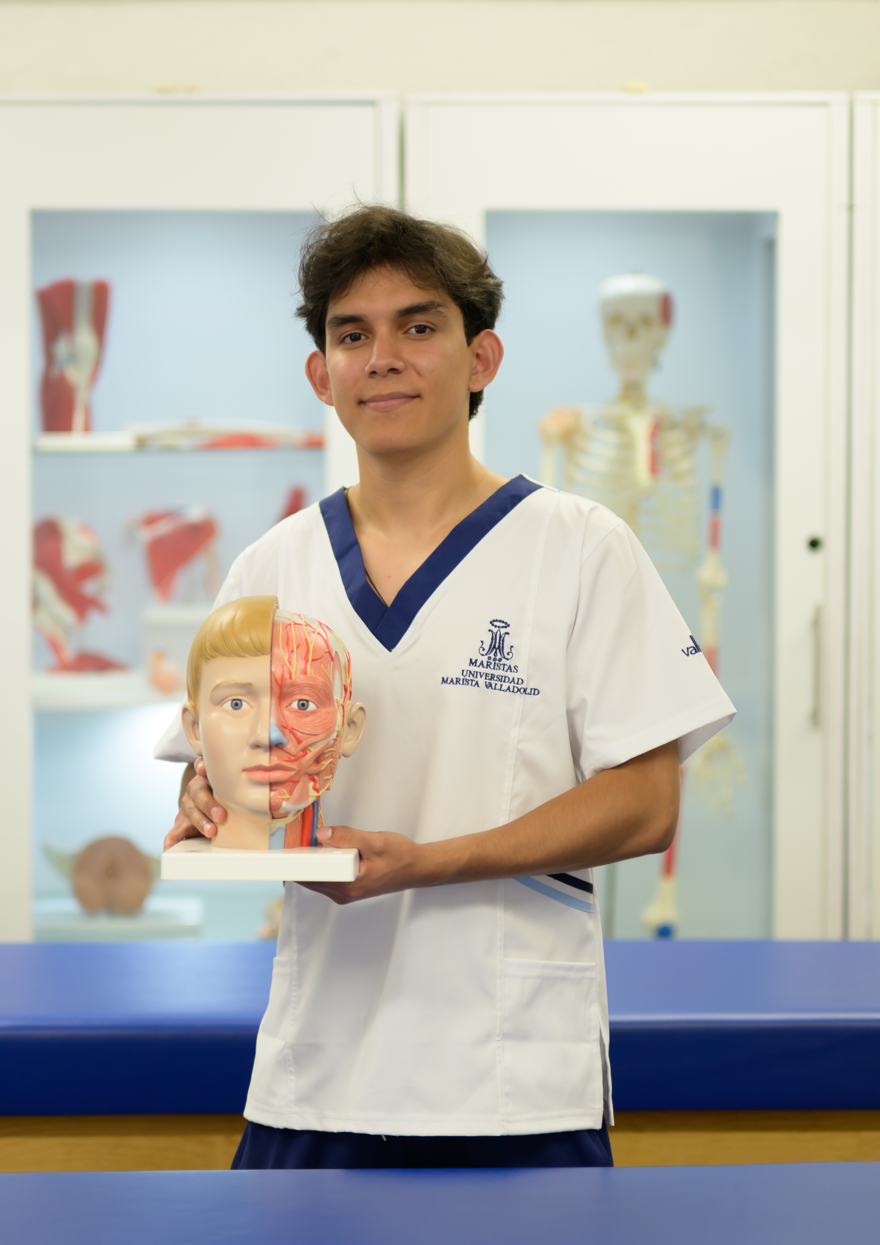 Estudiante de preparatoria sosteniendo un modelo anatómico