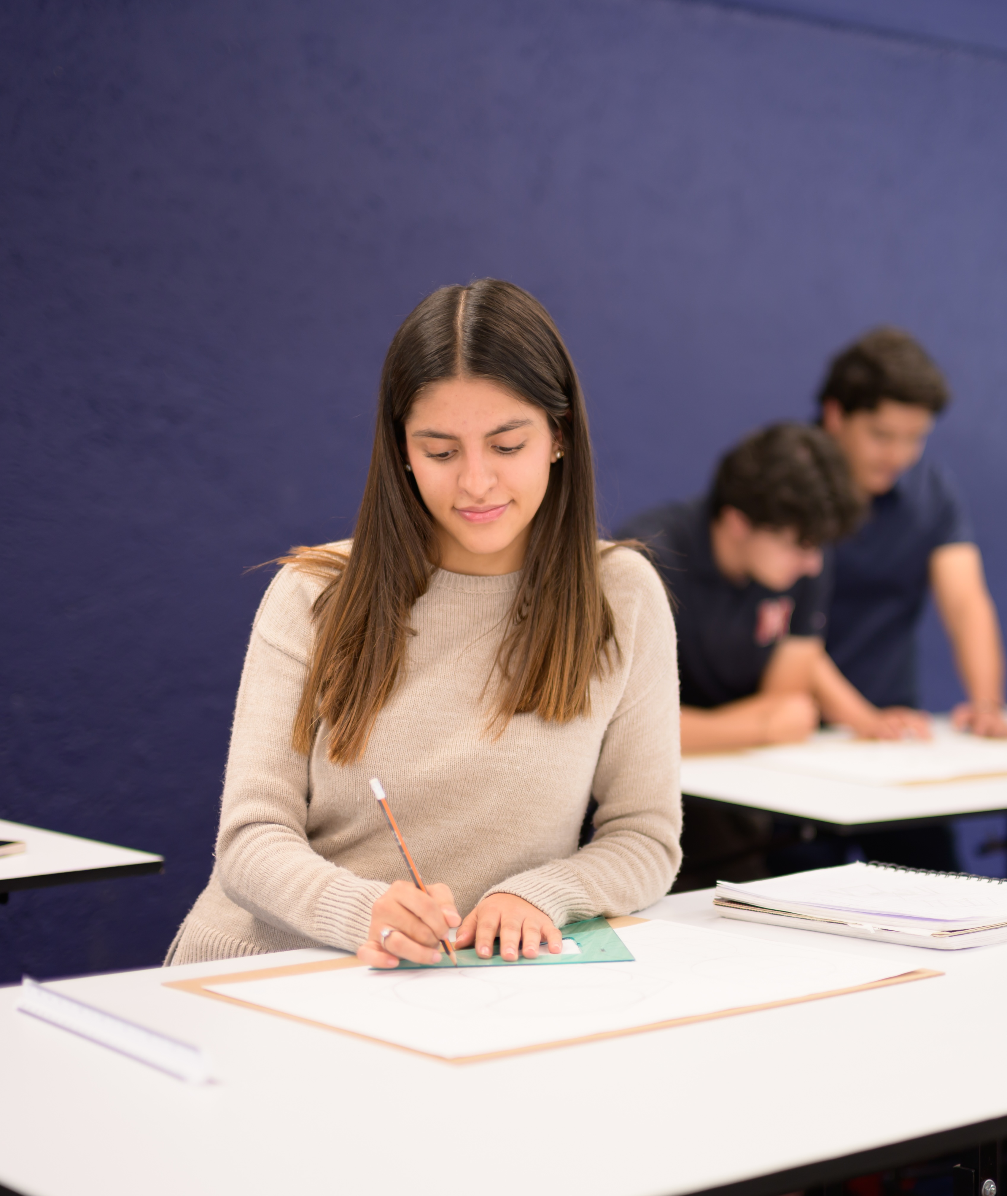 Estudiante escribiendo en un cuaderno durante una clase