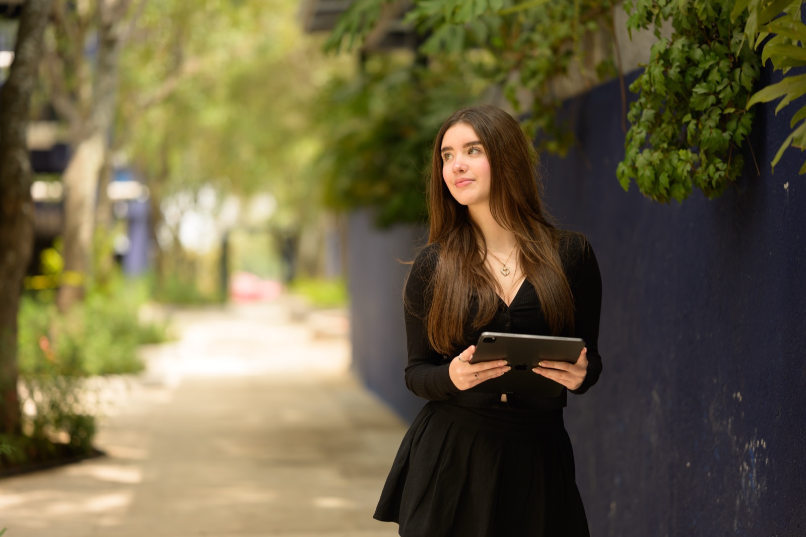 Estudiante con una tableta en un andador del campus