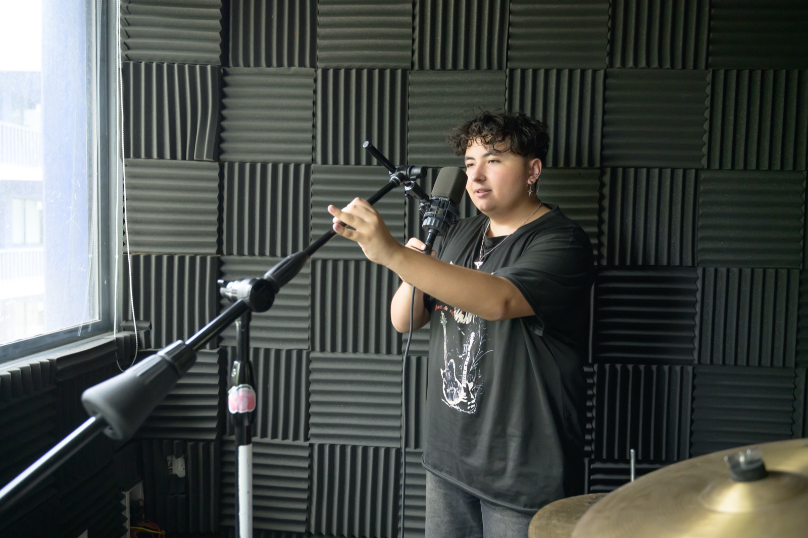 Estudiante ajustando un micrófono en la sala de música