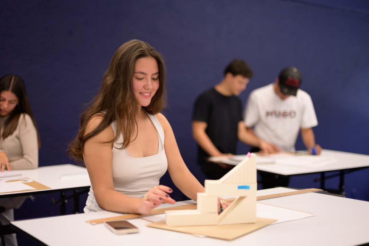 Estudiante de UMValla trabajando en su restirador en el taller de dibujo.