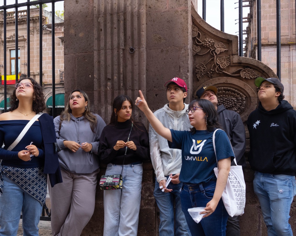 Estudiantes de UMValla observando la fachada de un edificio historico.