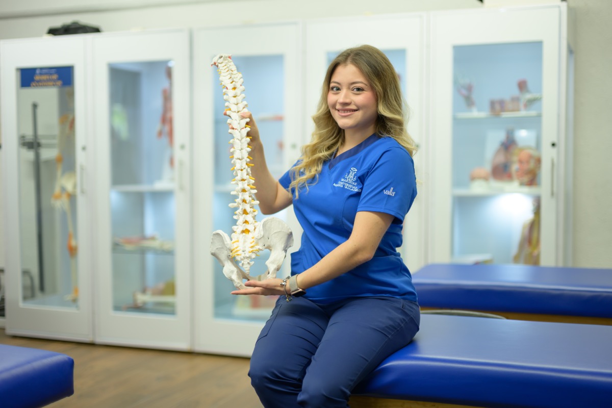 Estudiante de UMValla con un modelo de columna en el laboratorio.