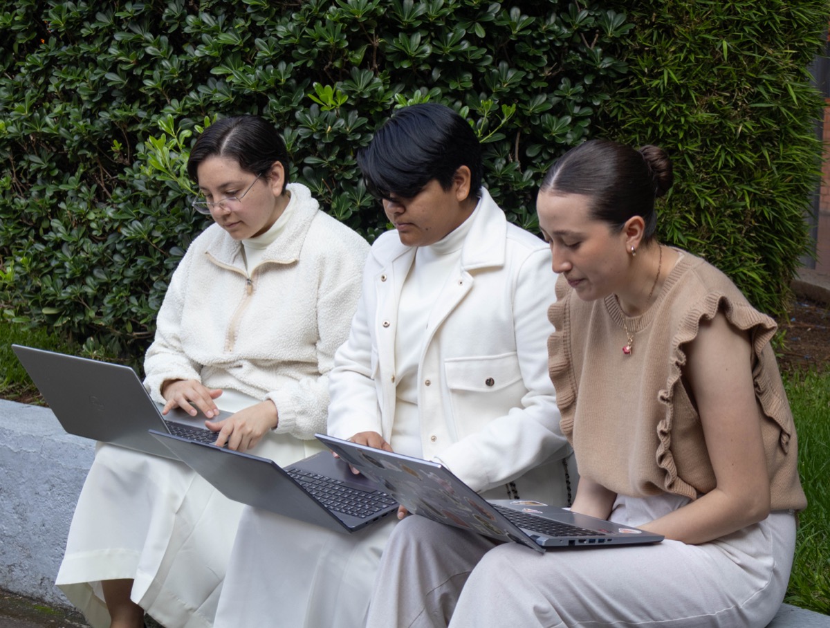 Estudiantes de UMValla trabajando con sus computadoras en los jardines.