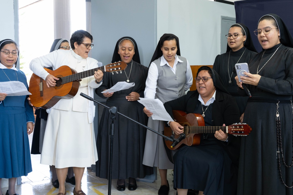 Estudiantes de UMValla cantando y tocando la guitarra en una celebracion.
