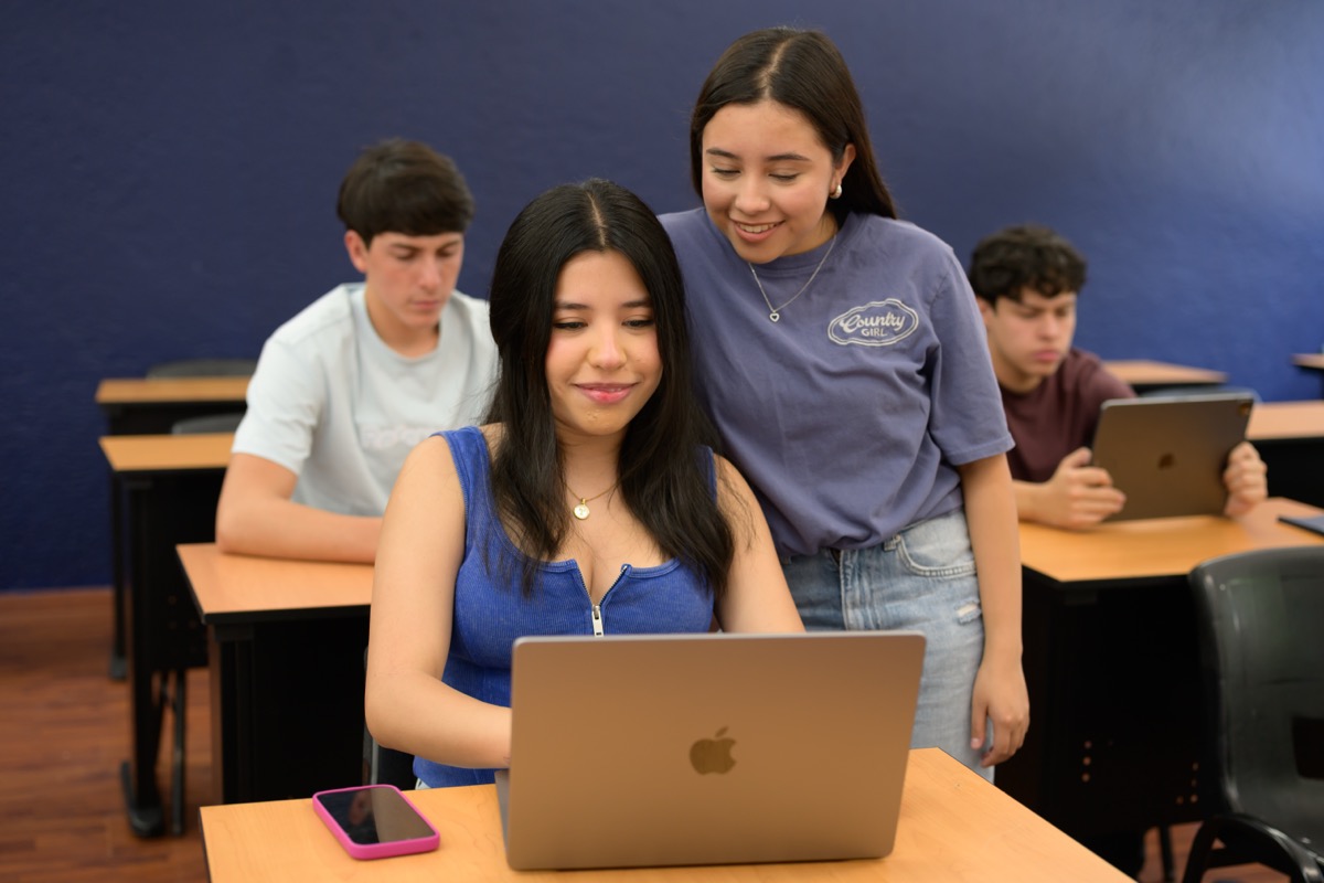Estudiantes de UMValla trabajando una campana frente a la computadora.