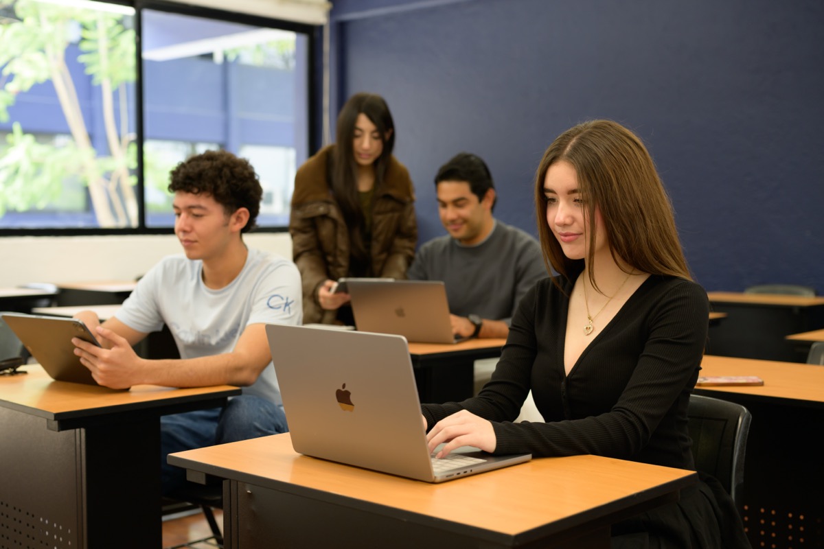 Estudiantes de UMValla trabajando con sus computadoras en el aula.