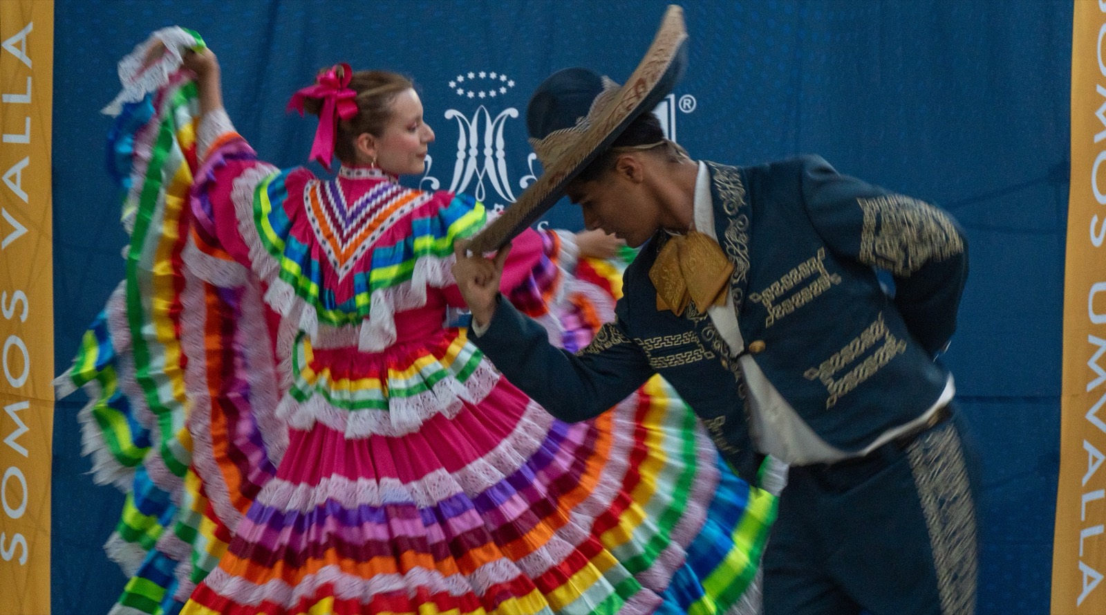 Pareja de alumnos bailando danza folclórica en un evento de la universidad